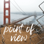 An opening in a chainlink fence looks over the Golden gate Bridge